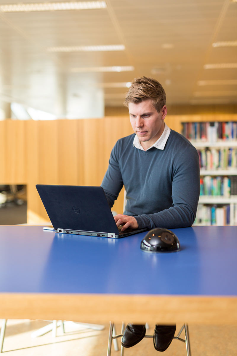 Student in library with laptop